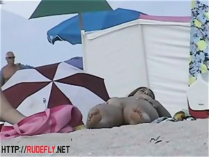 Beach sweethearts dangle out naked below the sun